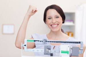 Smiling young woman happy about what the scale shows
